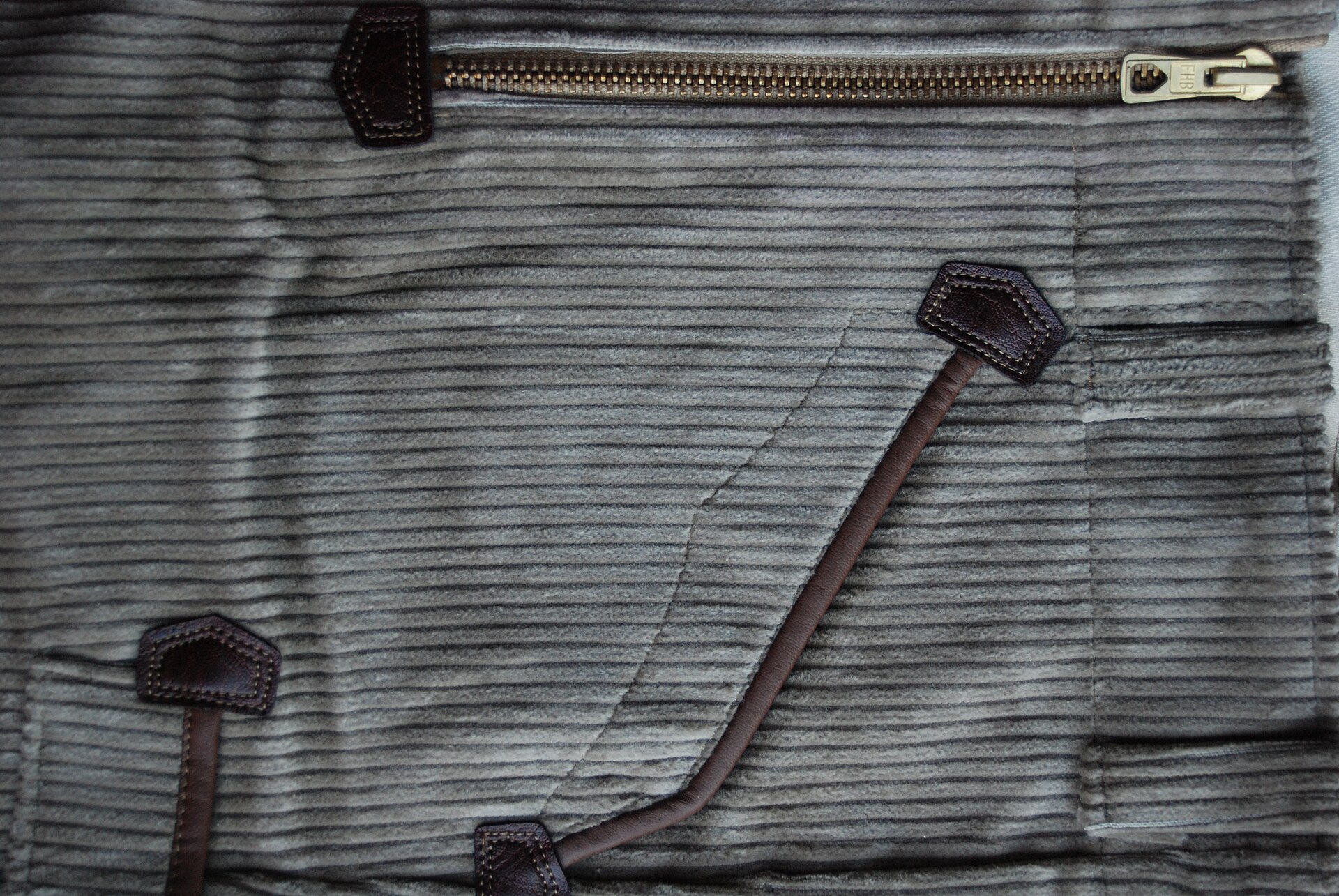 Close capture of beige 5-wale corduroy with zippers and brown artificial leather piping