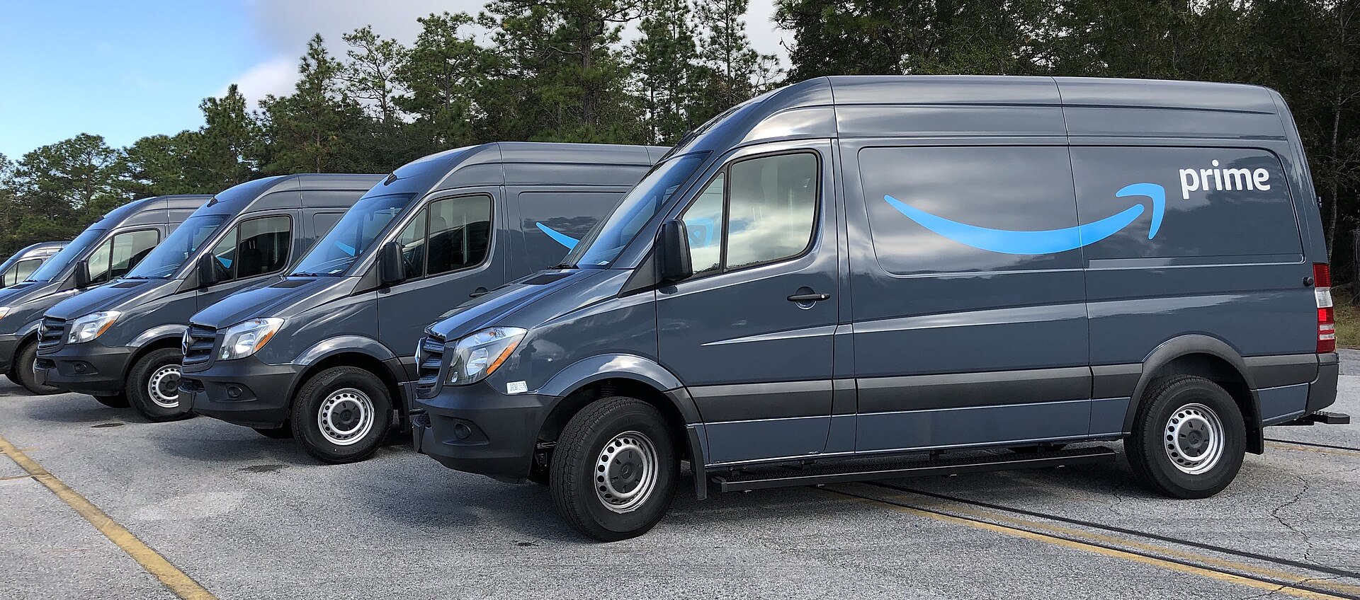 A row of grey Amazon Prime delivery vans parked side by side in Gainesville, Florida
