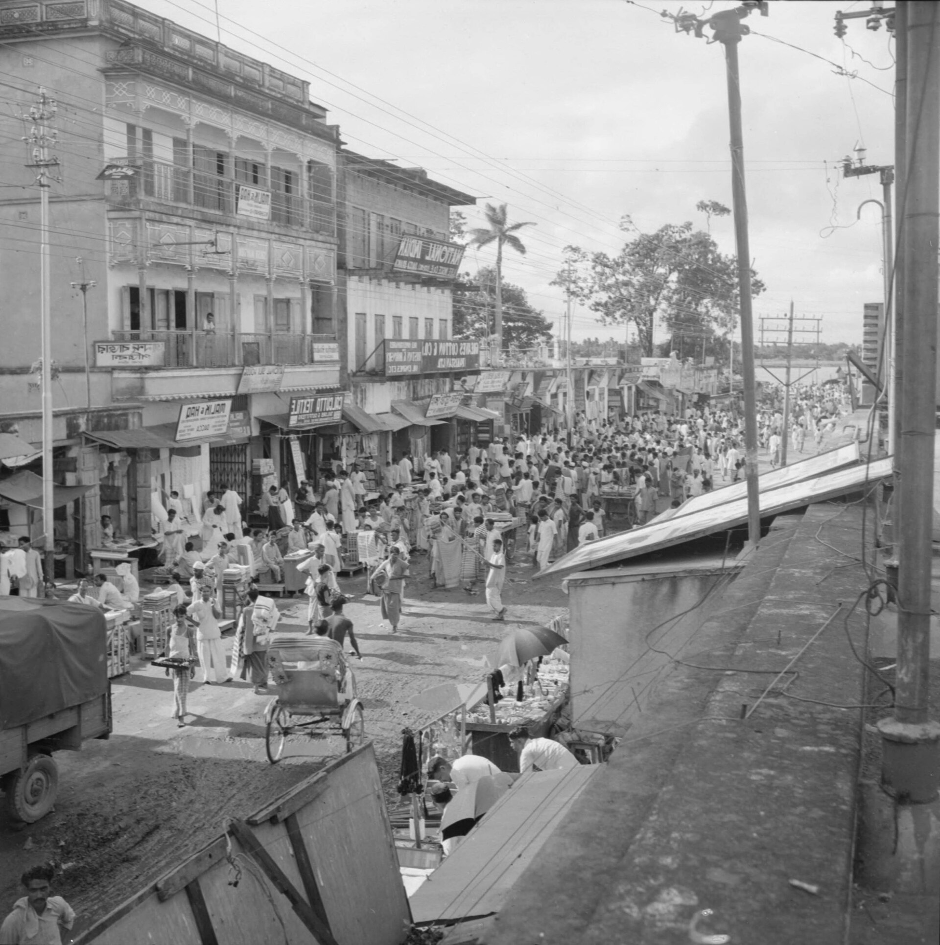 Title: Crowded open-air textile market in Dhaka, Bangladesh Subject: People Markets Textiles Stores & shops Signs (Notices) Photographer's N