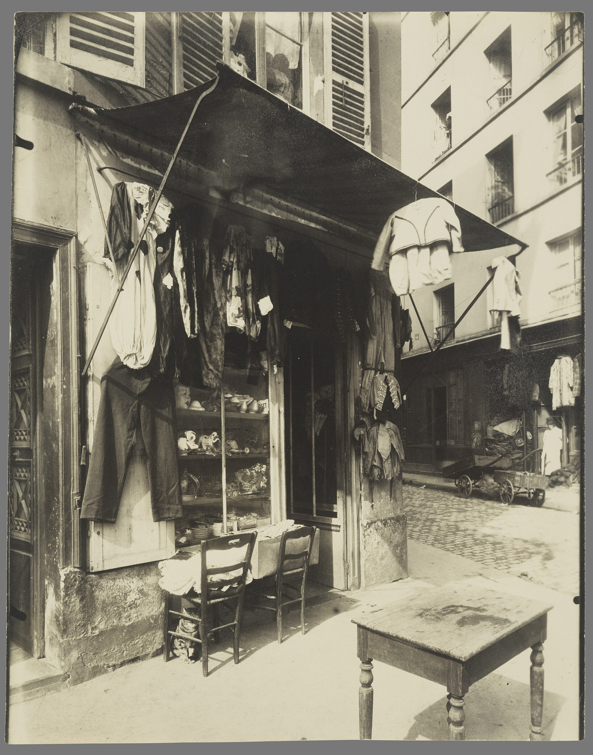 Masks, shoes, and a crown line the shelves of the window, while a clown suit and a child's military jacket adorn the facade of this extremel